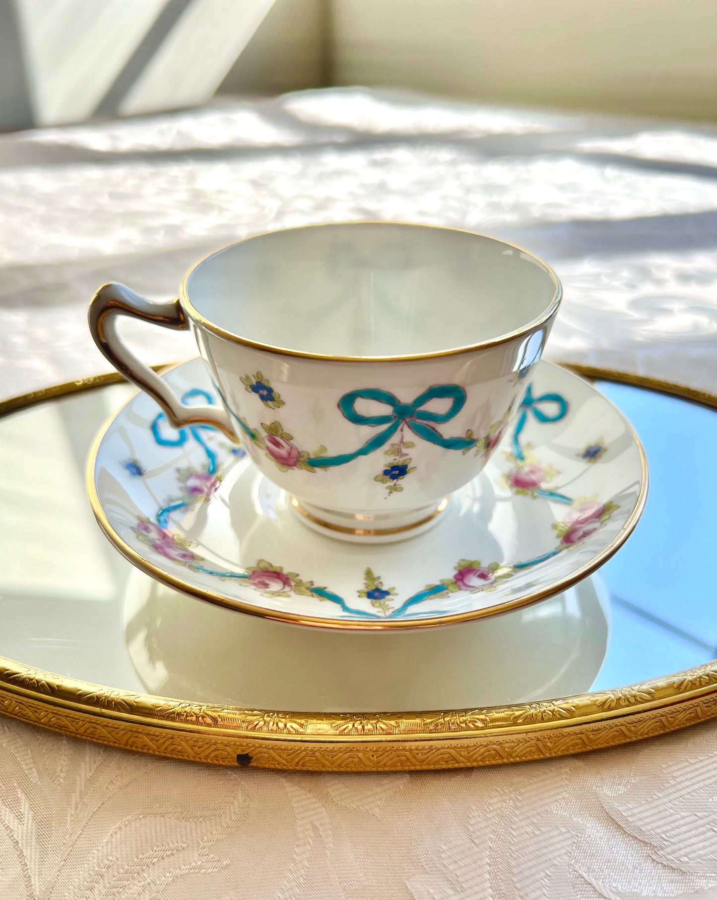 Crown Staffordshire bright blue enameled ribbon and looped bows pattern teacup and saucer