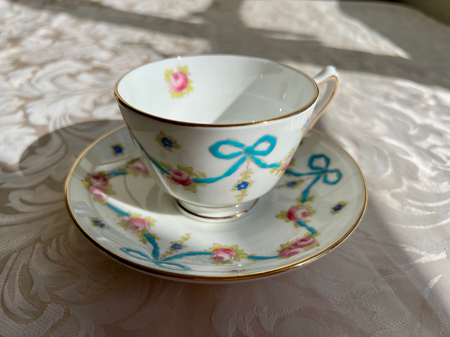 Crown Staffordshire bright blue enameled ribbon and looped bows pattern teacup and saucer