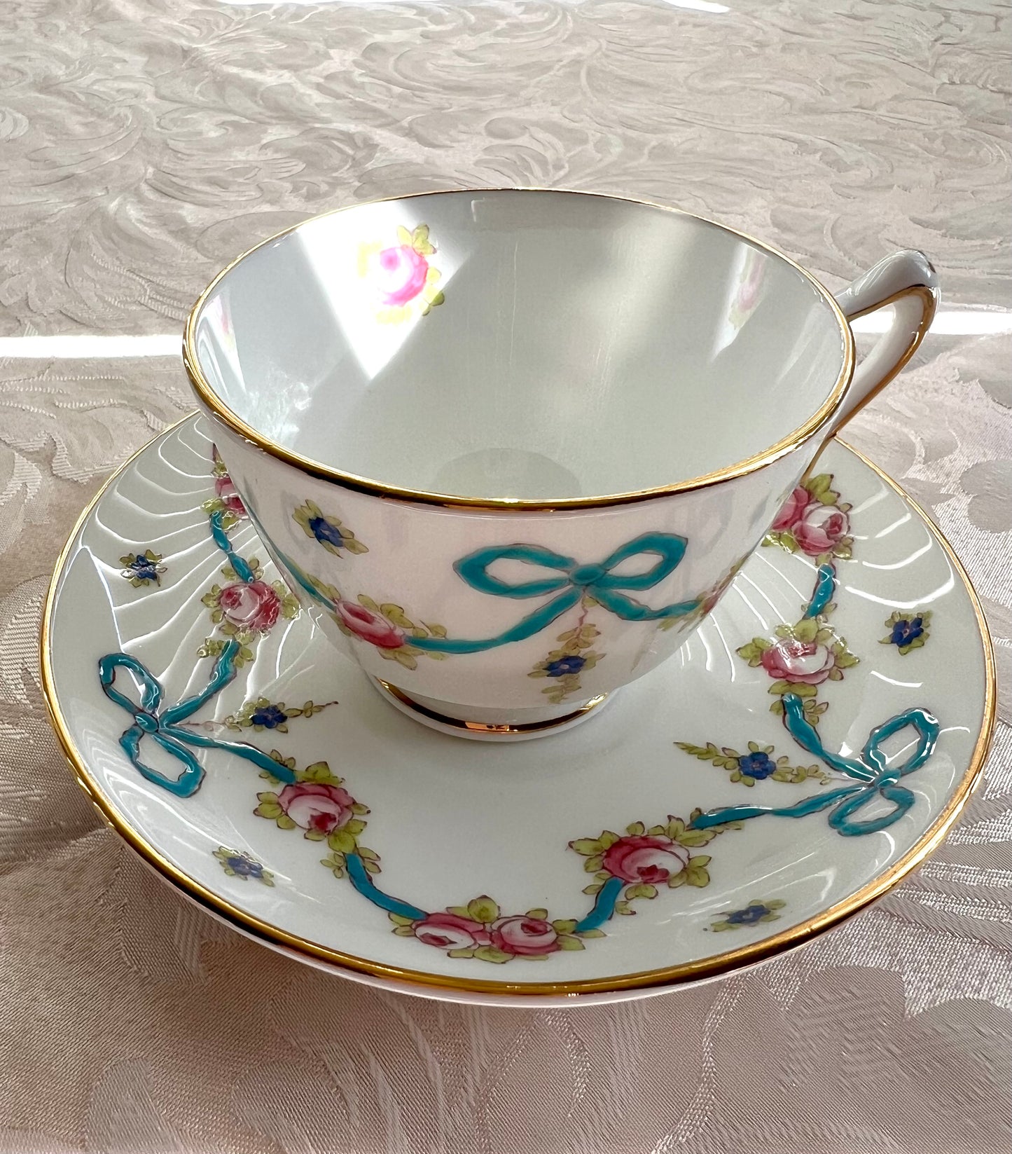 Crown Staffordshire bright blue enameled ribbon and looped bows pattern teacup and saucer