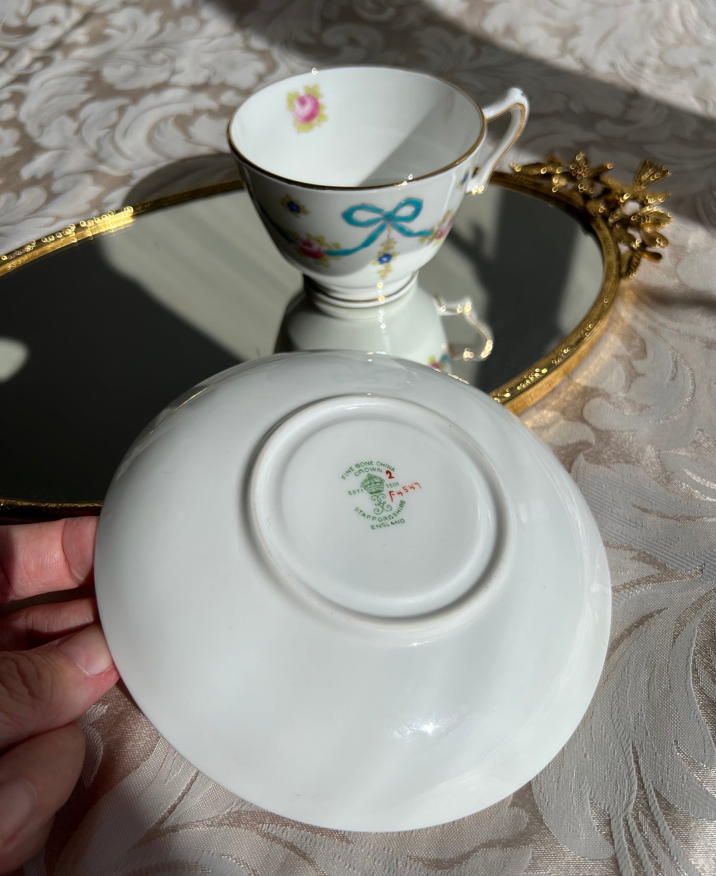 Crown Staffordshire bright blue enameled ribbon and looped bows pattern teacup and saucer