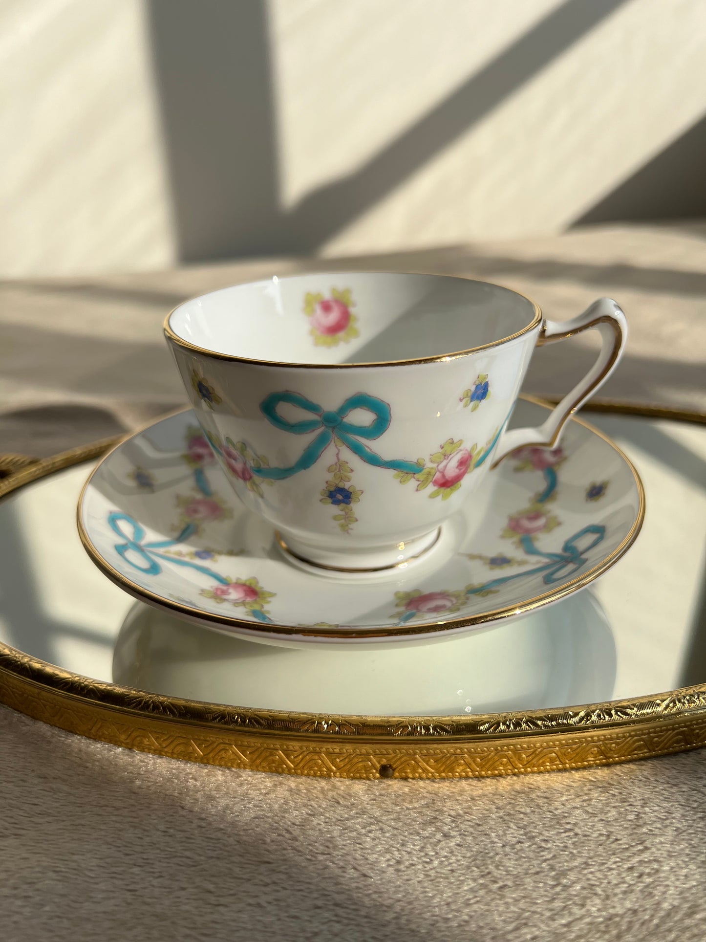 Crown Staffordshire bright blue enameled ribbon and looped bows pattern teacup and saucer